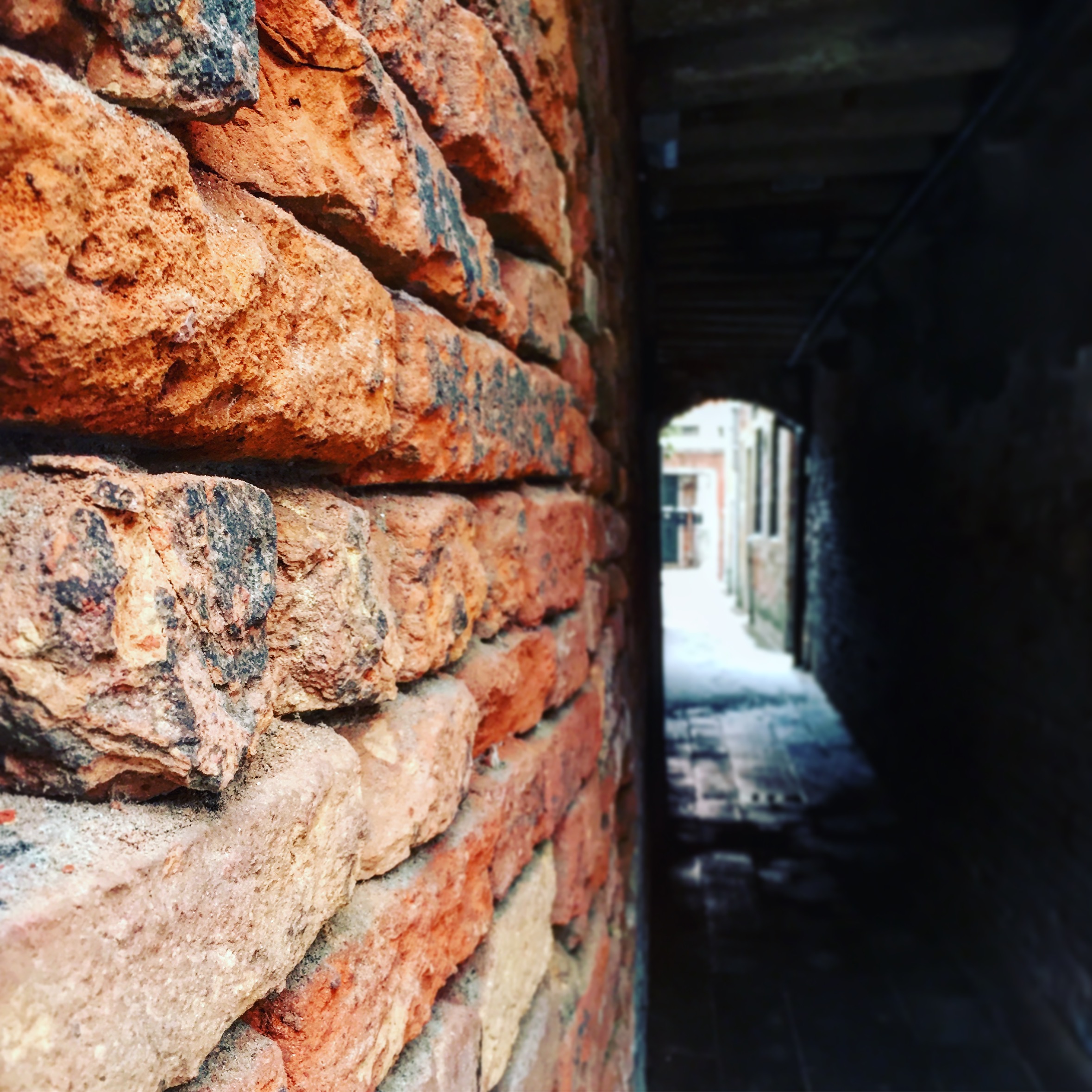 Mur de briques anciennes le long d'une ruelle historique